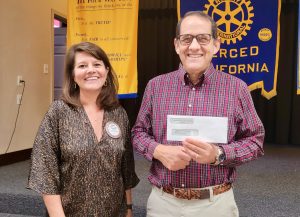 Don Barclay, president of the Friends of the Merced County Library, accepts a check from Mary Camper of the Merced Rotary Club for $5,000 as a donation to the Mary Hofmann Teen Center.