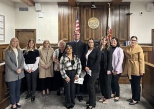 Members of CASA’s Class 56 pose for a photo with Judge Don Proietti.